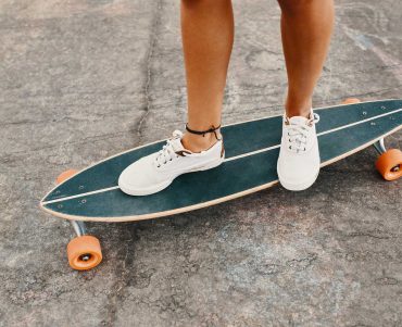 woman-in-sneakers-riding-skateboard-outdoor-on-asp-KXD8CUS.jpg